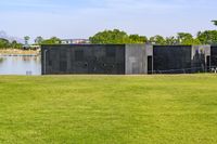 an open space with a small pond on one side, and a concrete structure on the other