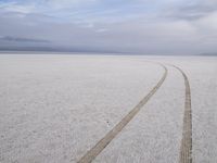 two tires are visible in this large open plain in front of clouds, with mountains in the distance