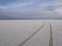 two tires are visible in this large open plain in front of clouds, with mountains in the distance