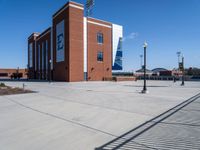 there is a large brick building on the sidewalk outside the stadium of the football team