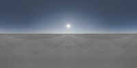 a very large expanse with a sun in the sky above it near some tracks and cars