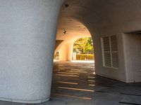 a man is riding his skateboard under an archway on the side walk of a building