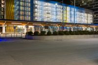 a large, modern building has many windows on each side of the building at night