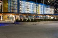 a large, modern building has many windows on each side of the building at night