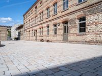 there is a bike leaning against the wall of some brick buildings and patios and a building with two buildings