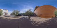 a fish eye view of an orange building with a staircase to it and a car parked behind it