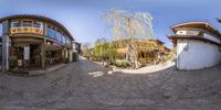 a 360 - cam image shows the reflection of several buildings in an alley in an oriental city