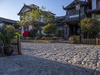 an oriental style home with its entrance covered in snow next to the walkway and fence