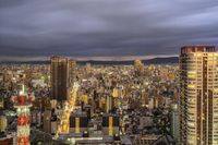 an image of the city at night with clouds above and buildings and mountains below in the background