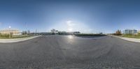 an upside down photo shows the intersection of a empty parking lot and several buildings and some grass