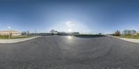 an upside down photo shows the intersection of a empty parking lot and several buildings and some grass