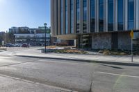 a yellow stop light in the middle of a street corner with a building and traffic