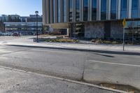 a yellow stop light in the middle of a street corner with a building and traffic