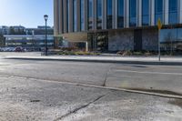 a yellow stop light in the middle of a street corner with a building and traffic