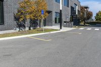 a stop sign is in front of a brick building on a street corner with yellow lines painted on