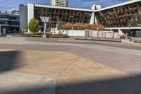 an empty plaza surrounded by tall buildings on a sunny day with the sky in the background