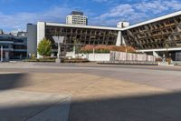 an empty plaza surrounded by tall buildings on a sunny day with the sky in the background