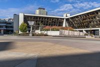 an empty plaza surrounded by tall buildings on a sunny day with the sky in the background