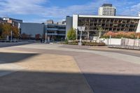 an empty plaza surrounded by tall buildings on a sunny day with the sky in the background