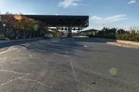 the view of a road with cars parked under an overpass next to it with a street light