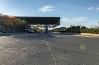 the view of a road with cars parked under an overpass next to it with a street light