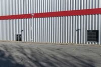 a red, gray and white building in a parking lot next to a fire hydrant