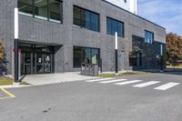 the entrance to the building with a paved surface and parking space on each side of it