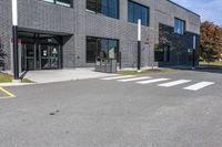 the entrance to the building with a paved surface and parking space on each side of it