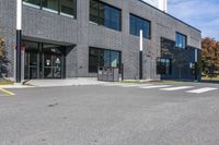 the entrance to the building with a paved surface and parking space on each side of it