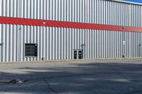 a red fire hydrant stands out the front of a building with a steel door