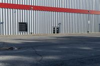 a red fire hydrant stands out the front of a building with a steel door