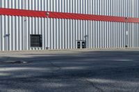 a red fire hydrant stands out the front of a building with a steel door