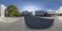 360 view of some office buildings across a street with a blue sky in the background