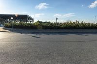 the skateboard is parked on the road at the side of the street with the trees in the background