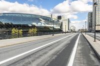 a road with some cars on it next to some buildings and a blue sky with clouds