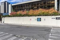 a picture of a building near a parking lot in the day time next to a crosswalk