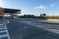 this is the intersection of a city street with an open bridge on one side, a stop sign on the other and a blue sky