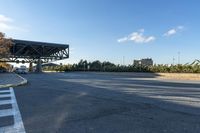 this is the intersection of a city street with an open bridge on one side, a stop sign on the other and a blue sky