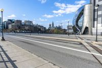 an empty city street with a sidewalk and a person walking across it that has a crosswalk in front of the intersection