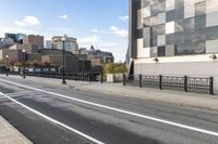 an empty city street with a sidewalk and a person walking across it that has a crosswalk in front of the intersection