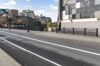 an empty city street with a sidewalk and a person walking across it that has a crosswalk in front of the intersection