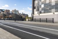 an empty city street with a sidewalk and a person walking across it that has a crosswalk in front of the intersection