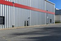 a building with a red strip on the side and windows near a red fire hydrant