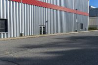 a building with a red strip on the side and windows near a red fire hydrant