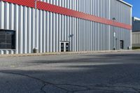 a building with a red strip on the side and windows near a red fire hydrant