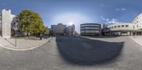 360 view of some office buildings across a street with a blue sky in the background