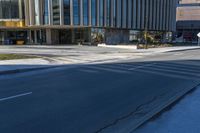 a blue fire hydrant on the side of a road next to tall buildings and a sidewalk