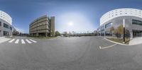 a 360 - lens photo of two buildings and an empty street with a bicycle on it