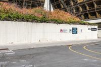 an asphalt lot with a road running down it and a wall near by it that has a parking sign on it