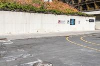 an asphalt lot with a road running down it and a wall near by it that has a parking sign on it